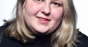 Headshot of Lauren Wimmer wearing a black shirt in front of a white background.