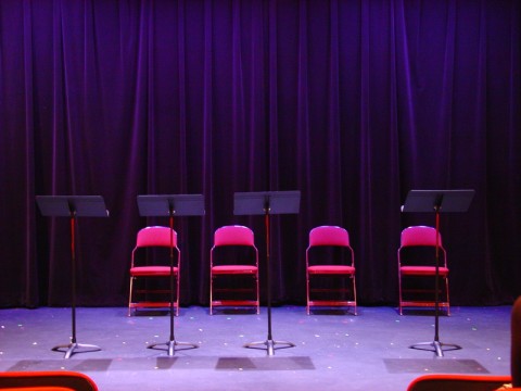 Four music stands and four chairs on the Playwrights' Center's stage.